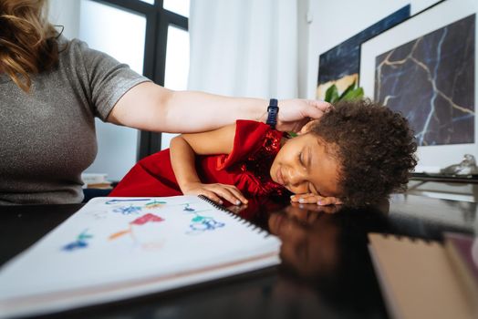 Little girl is studying, tired of studying the child lay down on the table, the schoolgirl is tired.