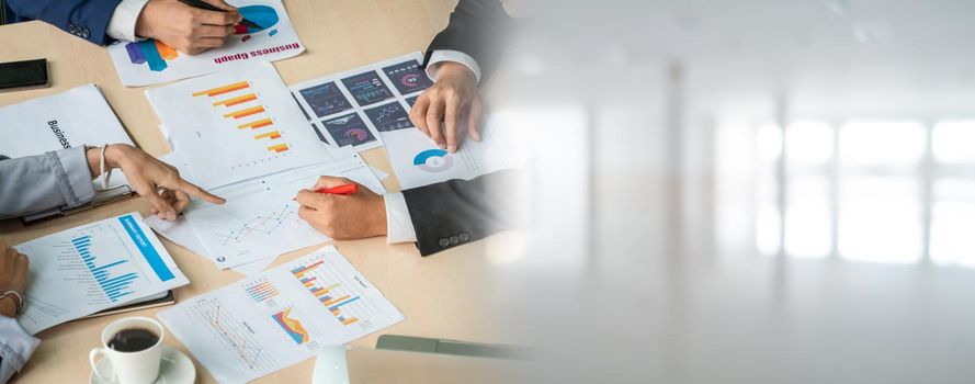 Smart businessman and businesswoman talking discussion in widen group meeting at office table in a modern office interior. Business collaboration strategic planning and brainstorming of coworkers.