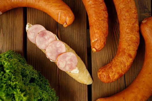 Polish kielbasa with cheese cream and bread on wooden background