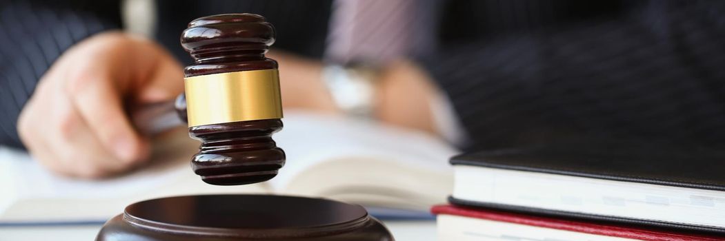 A man in a judge's gavel in his hands, close-up, blurry. Charity auction, legal dispute, criminal liability
