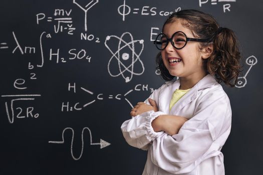 funny little girl scientist with glasses laughing