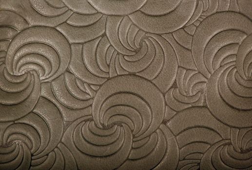 Texture of gray genuine leather with embossed floral trend pattern close-up, color, for wallpaper or banner design