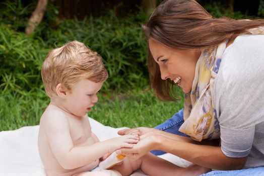 A young mother sitting outside with her infant son.