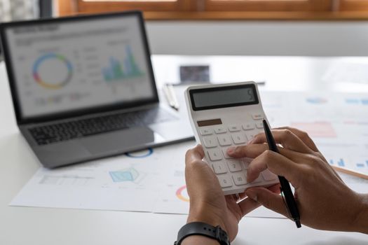 Close up a man working about financial with calculator at his office to calculate expenses, Accounting concept.
