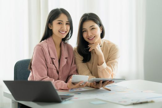 Portrait of Asian Businesswoman and Accountant checking data document on digital tablet for investigation of corruption account. Anti Bribery concept