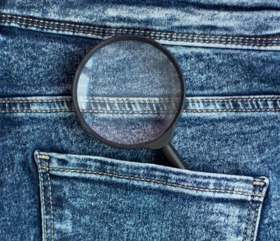 magnifier in the back pocket of jeans. Constant search concept. Back pocket. Stitching on jeans. High quality photo