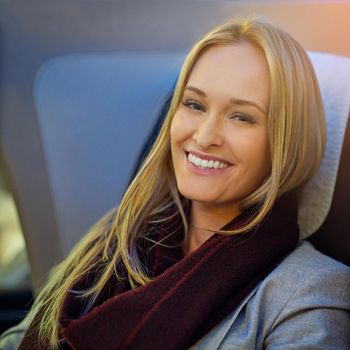 Portrait of a young woman sitting in first class on an airplane.
