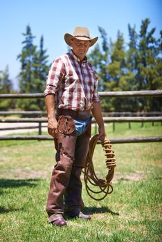 A mature cowboy outdoors on his farm.