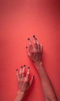 Happy Halloween concept. Creepy woman Halloween hands with black nails on red bloody background