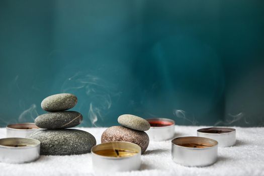 Zen concept, spa pebbles stones and burning aroma candles smoke on blurred background, Treatment aromatherapy and massage, copy space for text