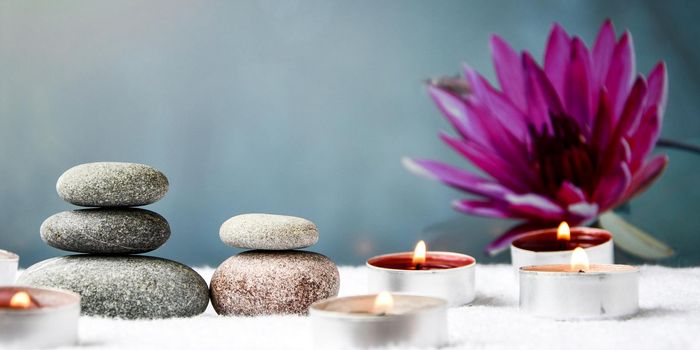 Zen concept, spa pebbles stones and burning aroma candles on blurred background, Treatment aromatherapy and massage, copy space for text