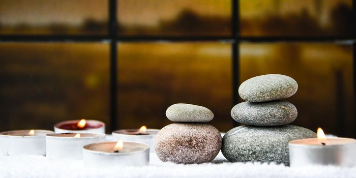 Zen concept, spa pebbles stones and burning aroma candles on blurred background, Treatment aromatherapy and massage, copy space for text