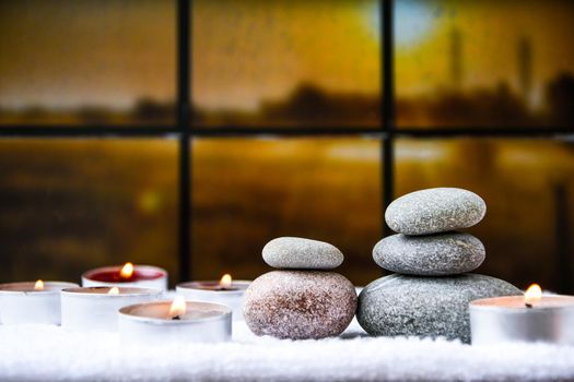 Zen concept, spa pebbles stones and burning aroma candles on blurred background, Treatment aromatherapy and massage, copy space for text