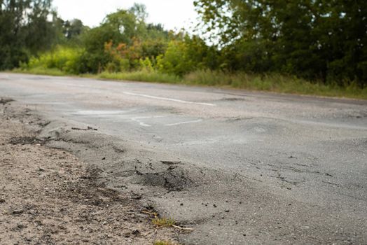 Low quality road after heavy trucks driving on it. Ignoring weight limit and damaging road