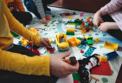 Kids playing with building blocks toys on a play mat