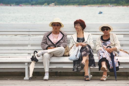 Sopot / Poland - August 3 2019: Three old ladies sat together chatting on a public bench at the beach