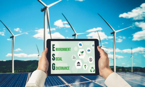 Green business transformation for environment saving and ESG business concept. Businessman using tablet to set corporate goal toward environmental friendly management and alternative clean energy use.