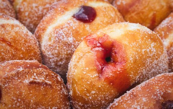 Close-up of a heap of jam-filled sugar-coated doughnuts
