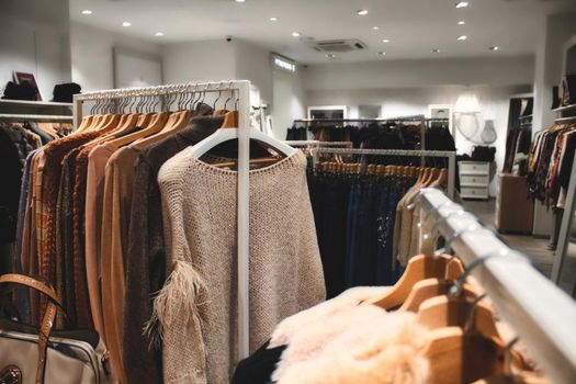 Interior of a clothes department store with ladies clothing hanging from racks