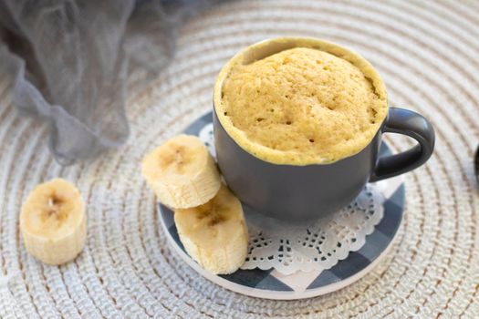 selective focus. homemade Portioned Banana bread mugcake in small mugs. Easy sweet baking in the microwave idea, With fresh bananas, nuts. Muffin with banana slices cooked in a mug. copy space.