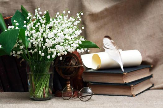 Still life with open book and quill pen near posy of white lilies