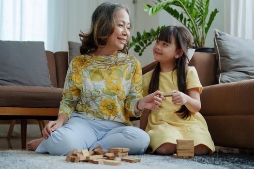 Asian portrait, grandma and granddaughter doing leisure activities and hugging to show their love and care for each other.