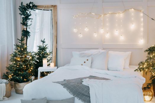 Tver, Russia-November 15, 2019. Embellished mirror, a large bed and a living Christmas tree with lights.