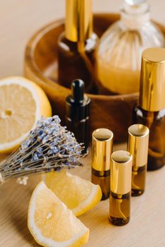 Essential oil in bottles with lemon and lavender fragrance, lying on a wooden surface.