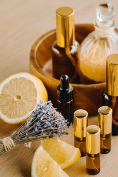 Essential oil in bottles with lemon and lavender fragrance, lying on a wooden surface.