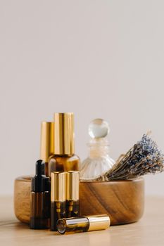 Essential oil in bottles with lavender fragrance, lying on a wooden surface.