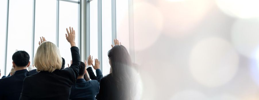 Group of business people meeting in a seminar conference widen view . Audience listening to instructor in employee education training session . Office worker community summit forum with speaker .