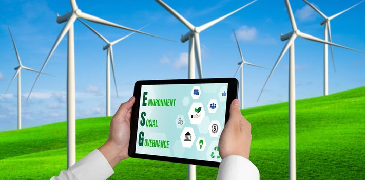 Green business transformation for environment saving and ESG business concept. Businessman using tablet to set corporate goal toward environmental friendly management and alternative clean energy use.