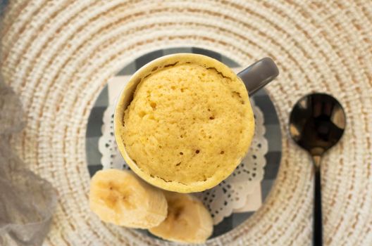 selective focus. homemade Portioned Banana bread mugcake in small mugs. Easy sweet baking in the microwave idea, With fresh bananas, nuts. Muffin with banana slices cooked in a mug. copy space.