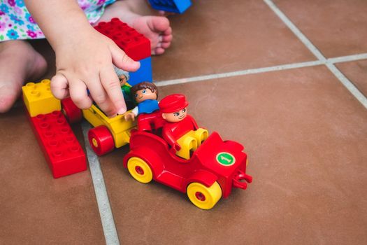 A  single child playing with Duplo toys, figures and vehicles