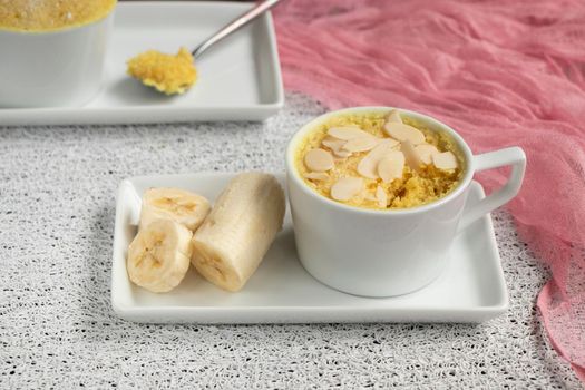 cupcake in a mug with banana pieces. Banana cupcake on a light background. The concept of a dessert in the microwave. bananas cake. High quality photo