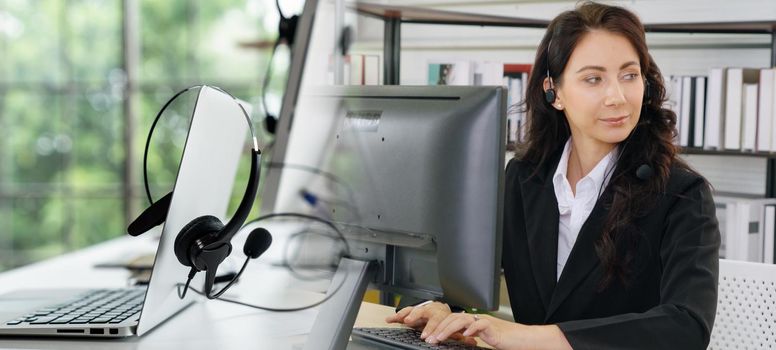 Business people wearing headset working in office to support remote customer or colleague. Call center, telemarketing, customer support agent provide service in broaden view .