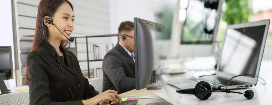 Business people wearing headset working in office to support remote customer or colleague. Call center, telemarketing, customer support agent provide service in broaden view .