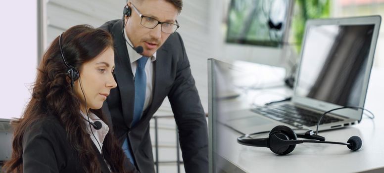 Business people wearing headset working in office to support remote customer or colleague. Call center, telemarketing, customer support agent provide service in broaden view .