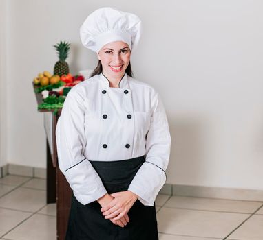 Portrait of a woman nutritionist in uniform with fresh vegetables on the table, A female nutritionist with a table of vegetables, Portrait of a female chef surrounded by fresh vegetables