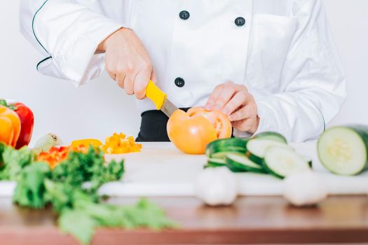 Chef woman hands cutting tomatoes and vegetables, Close up of chef woman hands cutting tomatoes and vegetables, chef hands preparing and cutting vegetables