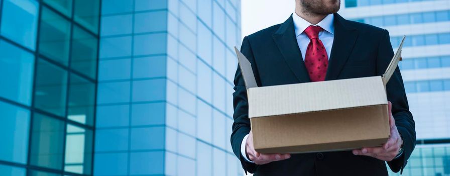 Businessman holding a paper box ready for moving.