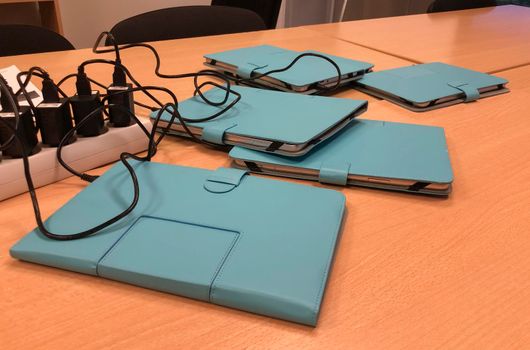 Several tablets on the table in the office on recharging