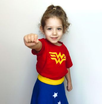 Portrait of a young cute girl posing as a super hero with Wonder Woman costume