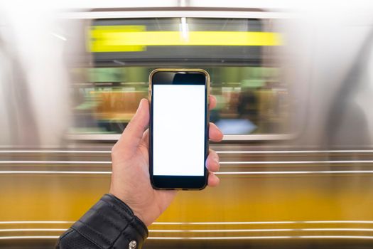 man holding phone in hand in the subway.