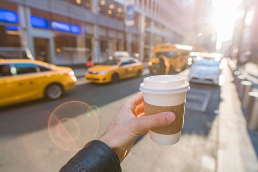 Hand holding coffee cup in New York City.