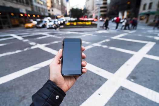 man holding a phone in the city.