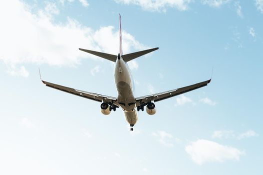 commercial aircraft flying seen from behind with the landing gear deployed, travel concept, copy space for text