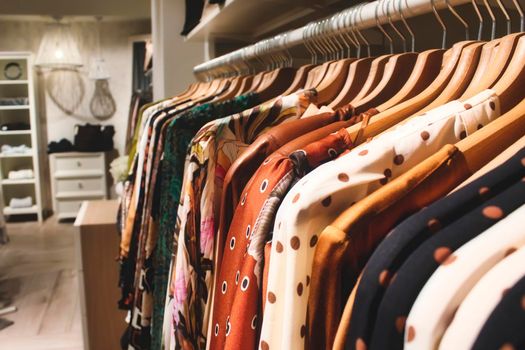 Close-up of tops and dresses in a wardrobe in a woman's bedroom