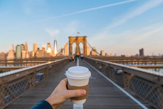 Hand holding coffee cup in New York City.