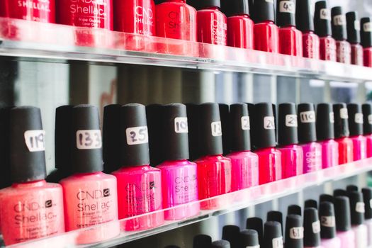 Rabat / Malta - December 8 2019: Rows of bottles of pink and red nail polish on shelves in a beauty spa